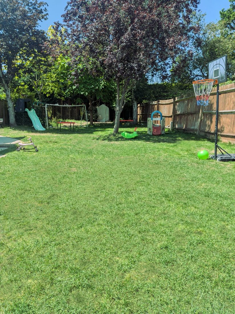 Spacious secure garden with swings, slide and play equipment