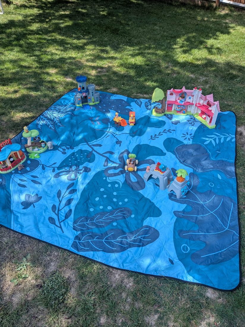 Small-world castle play scene on a garden play mat